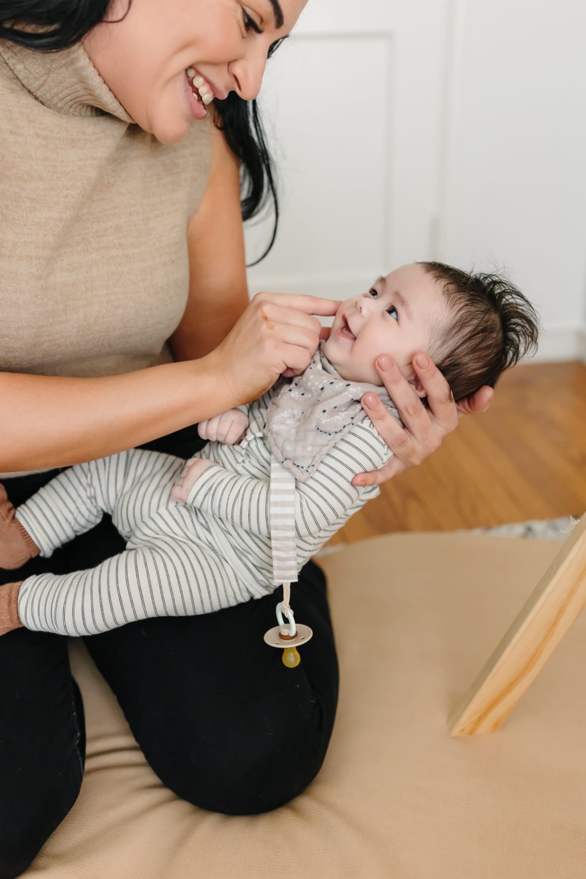 Ashlee sharing a tender, smiling moment face‑to‑face with a baby in her arms