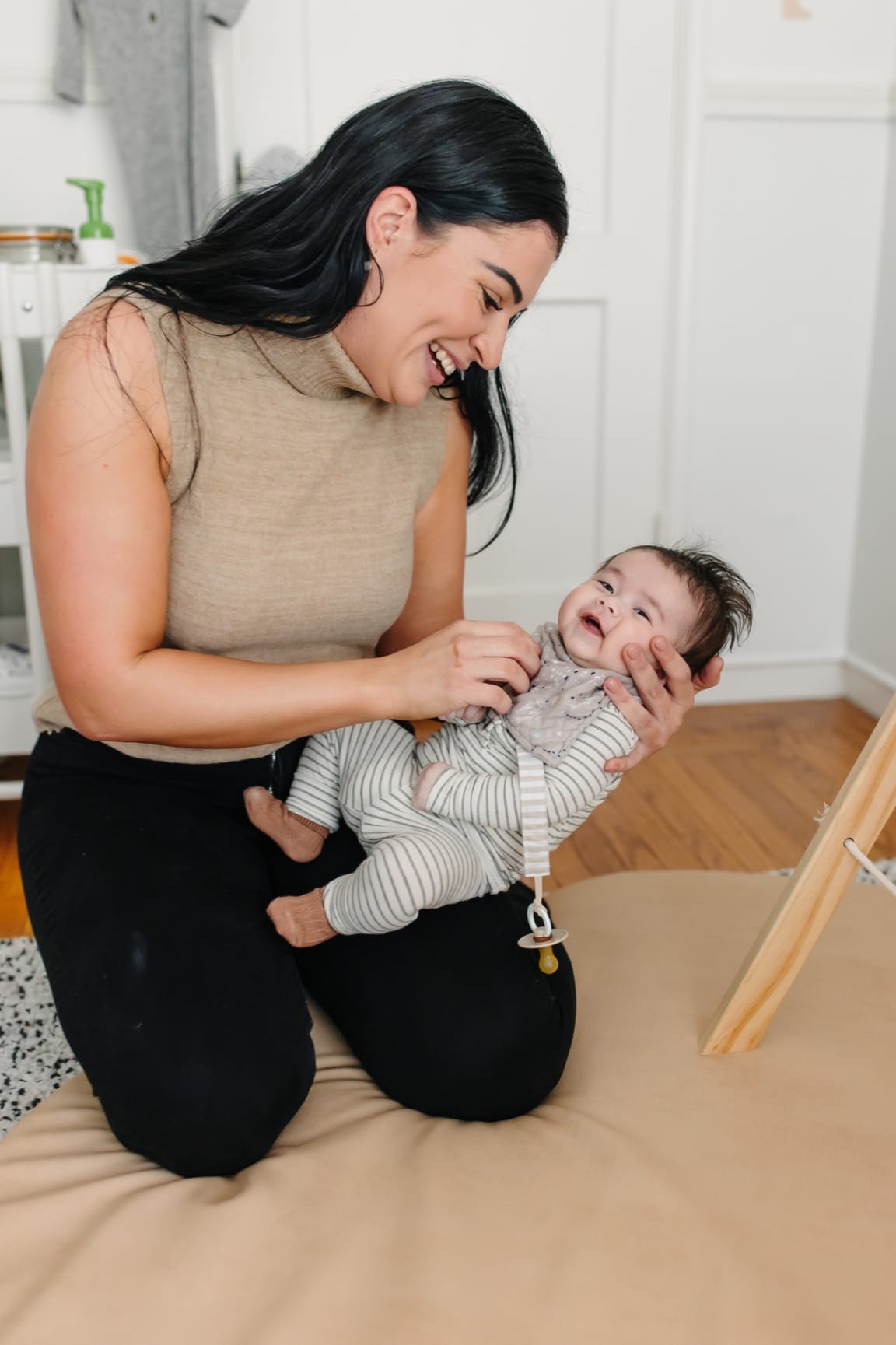 Ashlee laughing warmly with a smiling baby cradled in her arms
