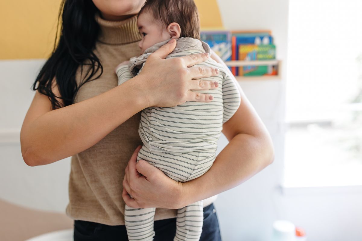 Ashlee McKenzie soothing a baby against her shoulder in a calm, sunlit nursery