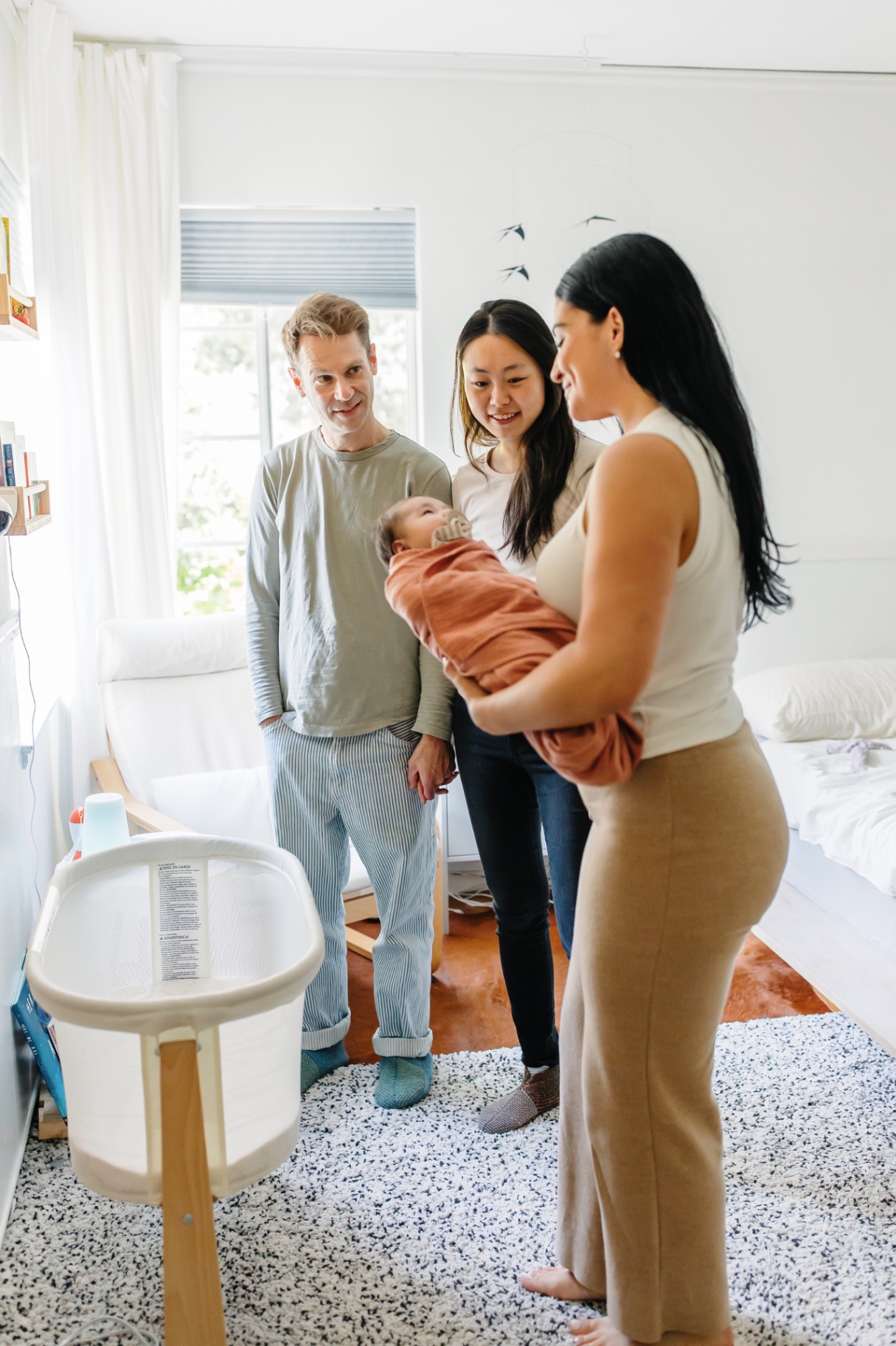 Ashlee McKenzie and both parents gathered close around their swaddled newborn in a San Francisco nursery
