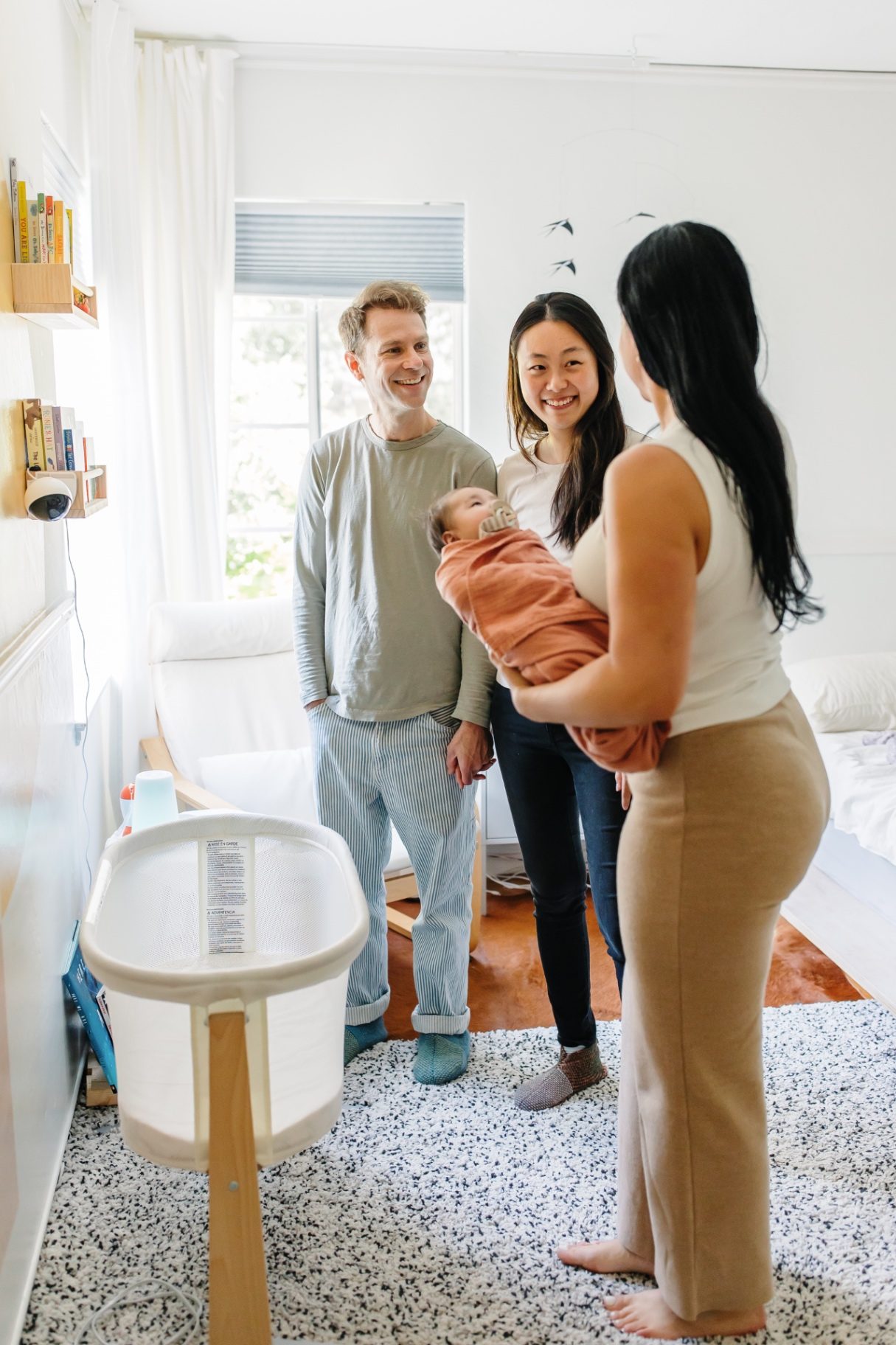 Ashlee visiting with new parents in their nursery while holding their baby